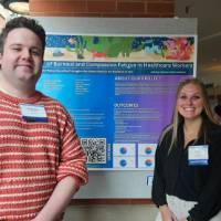 Anthony Caprara and Cally Goodman standing in front of their poster presentation